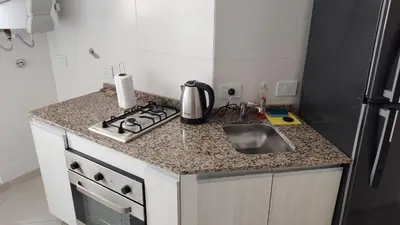 a kitchen counter with a sink and a stove at departamento de dos dormitorios in Cordoba