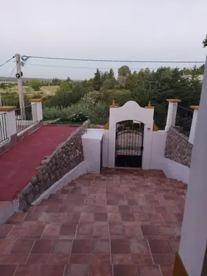 a gate to a house with a red brick patio at La Casona de Cerro Colonial in Trapiche