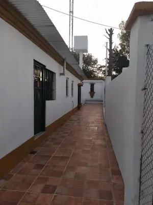 a corridor of a white building with a fence at La Casona de Cerro Colonial in Trapiche