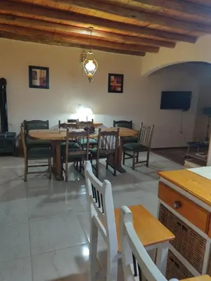 a dining room with wooden tables and chairs at La Casona de Cerro Colonial in Trapiche