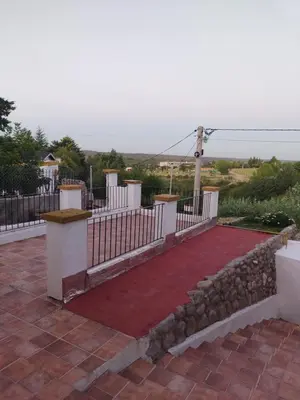 a fence with a red carpet and a stone wall at La Casona de Cerro Colonial in Trapiche