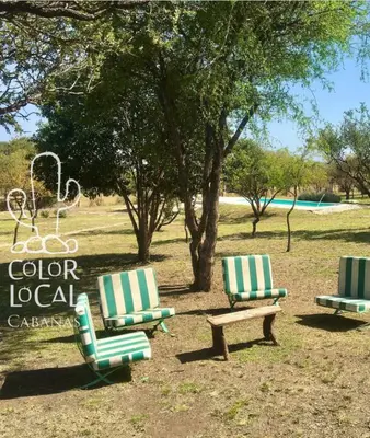 three chairs and a bench in a park at Color Local Cabañas in San Javier