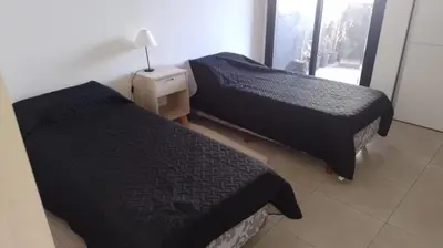 a bedroom with two beds and a lamp on a table at Lake360 Dto 51 in Villa Carlos Paz
