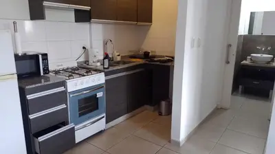 a small kitchen with a stove and a sink at Lake360 Dto 51 in Villa Carlos Paz