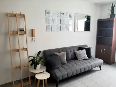 a living room with a gray couch and a table at BV ILLIA TERMINAL DE OMNIBUS in Cordoba