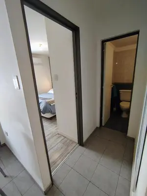 a hallway with a mirror and a room with a bed at BV ILLIA TERMINAL DE OMNIBUS in Cordoba