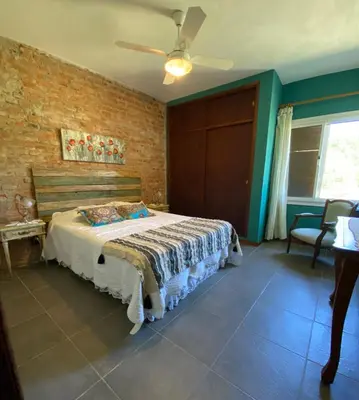 a bedroom with a bed and a ceiling fan at Posada Sausalito in Santa Rosa de Calamuchita