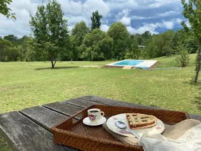 a picnic table with a cake and a cup of coffee at Posada Sausalito in Santa Rosa de Calamuchita