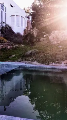 a pool of water in front of a house at La Flor del Camino Posada in Tanti