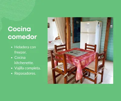 a table and chairs in a kitchen with a refrigerator at Cabaña Mateo in Cordoba