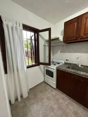 a kitchen with a stove and a sink and a window at Encantos del Valle - Santa Rosa de Calamuchita in Santa Rosa de Calamuchita