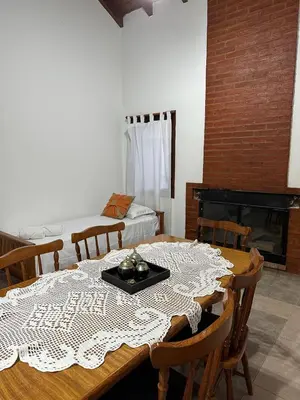 a dining room with a table and a fireplace at Encantos del Valle - Santa Rosa de Calamuchita in Santa Rosa de Calamuchita