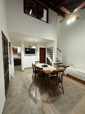 a dining room with a table and chairs and a bedroom at Encantos del Valle - Santa Rosa de Calamuchita in Santa Rosa de Calamuchita