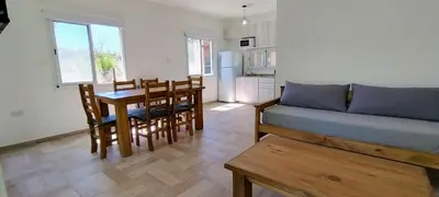 a living room with a couch and a table and chairs at Cabañas Madre Sierra in Santa Rosa de Calamuchita