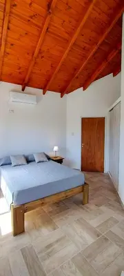 a bedroom with a bed and a wooden ceiling at Cabañas Madre Sierra in Santa Rosa de Calamuchita