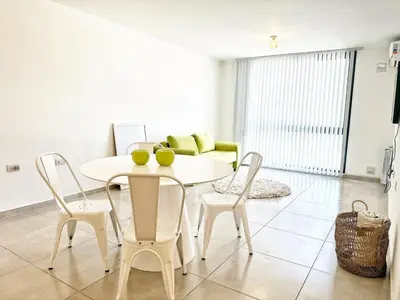 a white dining room with a white table and chairs at Edificio Darwin in Villa Carlos Paz