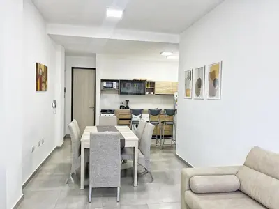 a dining room and living room with a table and chairs at Edificio Darwin in Villa Carlos Paz