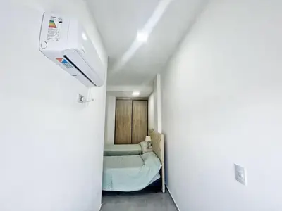 a small room with a bed and a air conditioner at Edificio Darwin in Villa Carlos Paz