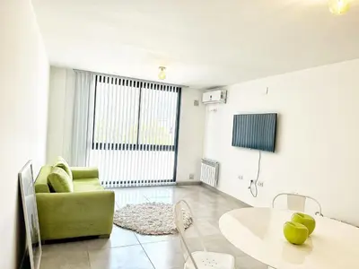 a living room with a green couch and a table at Edificio Darwin in Villa Carlos Paz