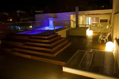a rooftop deck with a hot tub and stairs at night at HOTEL CONTINENTAL PLAZA in Villa Carlos Paz