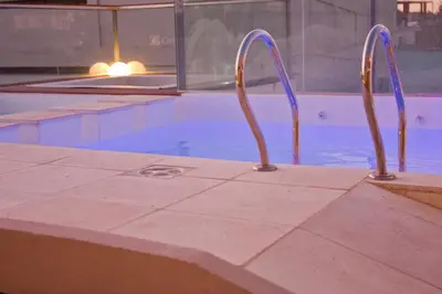 a swimming pool with two metal rails next to a swimming pool at HOTEL CONTINENTAL PLAZA in Villa Carlos Paz