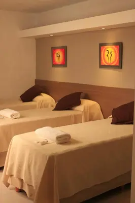 a hotel room with three beds with towels on them at HOTEL CONTINENTAL PLAZA in Villa Carlos Paz