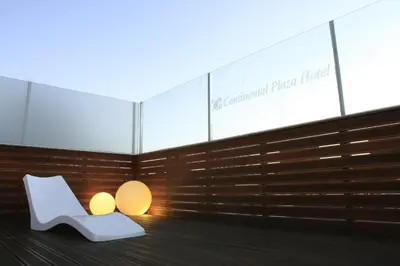 a white chair and two lamps in a room at HOTEL CONTINENTAL PLAZA in Villa Carlos Paz