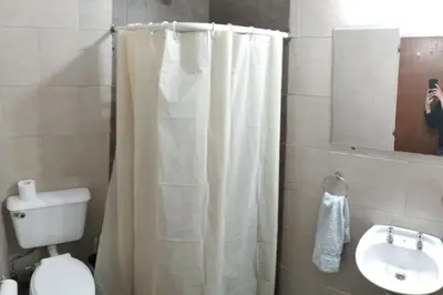a bathroom with a shower curtain and a toilet and a sink at Casa/ Villa General Belgrano in Villa General Belgrano