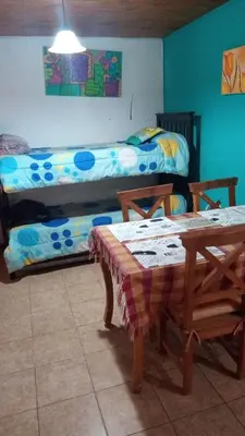 a room with two beds and a table and chairs at Sol Naciente in Potrero de Garay
