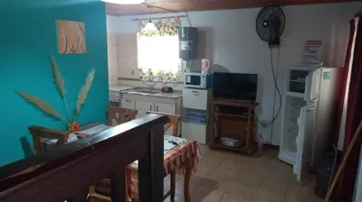 a kitchen with a refrigerator and a table and chairs at Sol Naciente in Potrero de Garay