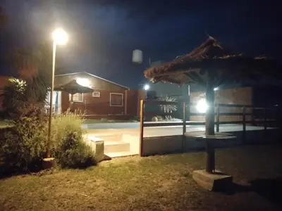 a patio with a umbrella and a house at night at Sol Naciente in Potrero de Garay