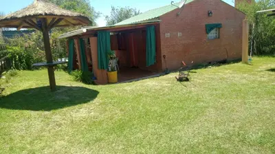 a small red building with a yard with a house at Sol Naciente in Potrero de Garay