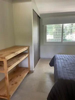 a bedroom with a bed and a desk and a window at La Franca Aparts in Villa General Belgrano