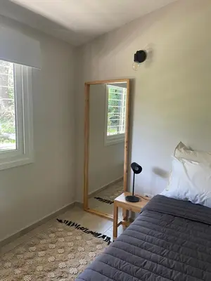 a bedroom with a bed and a mirror at La Franca Aparts in Villa General Belgrano