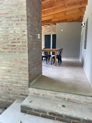 a dining room with a brick wall and a wooden table at La Franca Aparts in Villa General Belgrano