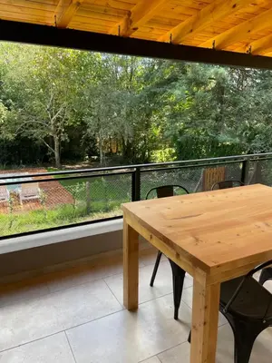 a wooden table and chairs on a balcony at La Franca Aparts in Villa General Belgrano