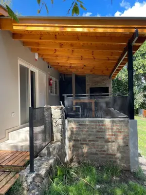 a patio with a wooden pergola at La Franca Aparts in Villa General Belgrano