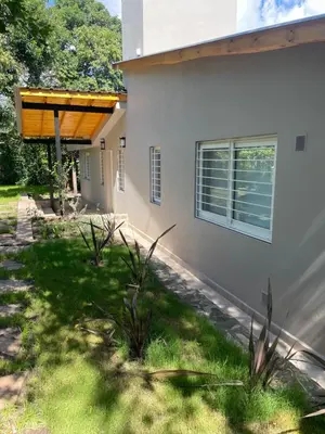 a house with a wooden awning on the side of it at La Franca Aparts in Villa General Belgrano