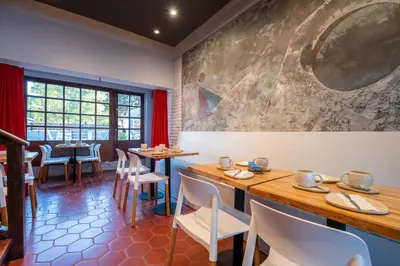 a restaurant with tables and chairs and a large painting on the wall at POSADA NEHUEN in Villa General Belgrano