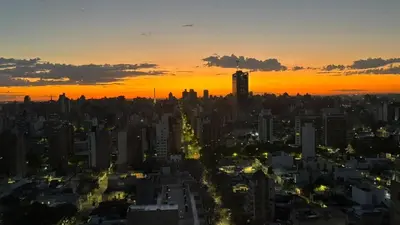 a city skyline with a sunset in the background at TORRES H in Cordoba