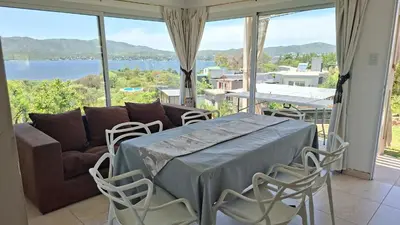 a living room with a couch and a table and chairs at El Mirador de los Manantiales in Villa Parque Siquiman