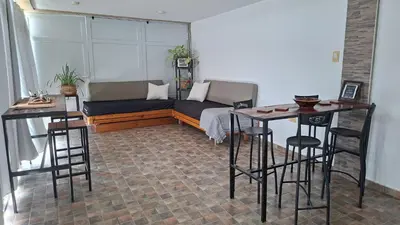 a living room with a couch and two bar stools at El Mirador de los Manantiales in Villa Parque Siquiman