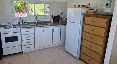 a kitchen with white cabinets and a white refrigerator at El Mirador de los Manantiales in Villa Parque Siquiman