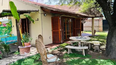 a patio with a table and chairs in front of a house at La Casa Nostra in Río Cuarto