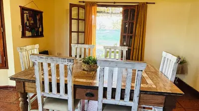 a dining room table with four chairs and a window at La Casa Nostra in Río Cuarto