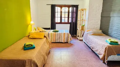two beds in a room with green and yellow at La Casa Nostra in Río Cuarto
