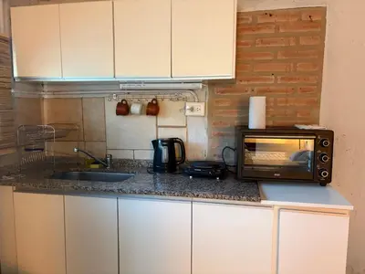 a kitchen counter with a microwave and a sink at Cardozo House Monoambiente acogedor y familiar in Villa Dolores