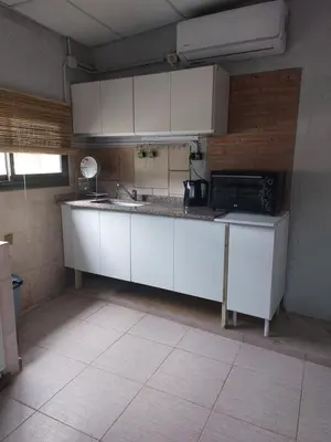 a kitchen with white cabinets and a black microwave at Cardozo House Monoambiente acogedor y familiar in Villa Dolores