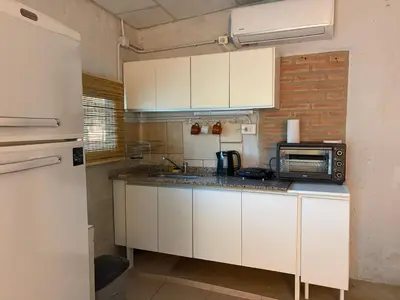 a kitchen with white cabinets and a microwave at Cardozo House Monoambiente acogedor y familiar in Villa Dolores