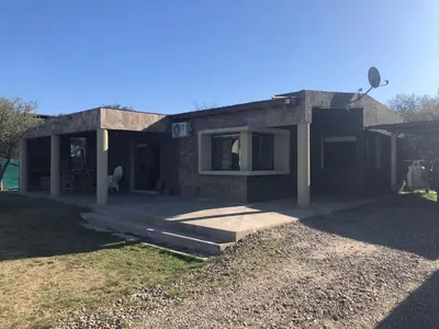 a small house with a porch and a yard at Casa en Santa Rosa de Calamuchita in Santa Rosa de Calamuchita